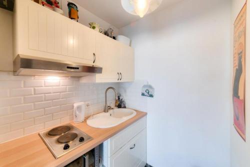 une petite cuisine avec des armoires blanches et un évier dans l'établissement La Fregate - maeva Home - Appartement 2 pièces 4 personnes - Sélection MAE-7994, à Trouville-sur-Mer