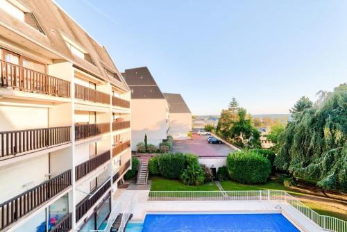 - une vue depuis le balcon d'un immeuble avec piscine dans l'établissement La Fregate - maeva Home - Appartement 2 pièces 4 personnes - Sélection MAE-7994, à Trouville-sur-Mer