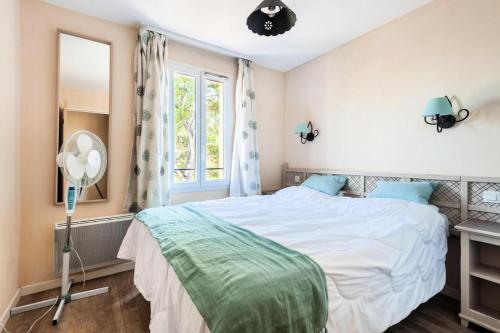 1 dormitorio con cama blanca y ventana en Les Coteaux de Pont Royal en Provence - maeva Home - Maison 4 pièces 6 pers 304, en Mallemort