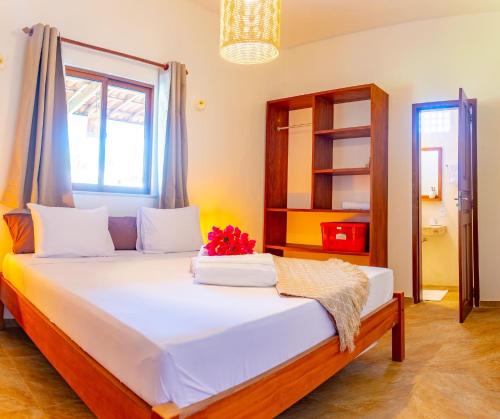 - une chambre avec un lit fleuri dans l'établissement Refugios Parajuru - Villa Palmeira, à Beberibe