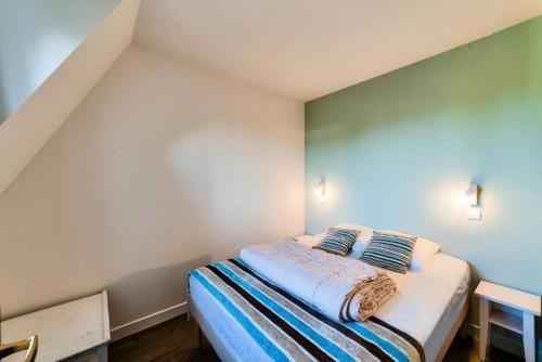 une chambre avec un lit avec deux oreillers dessus dans l'établissement La Résidence du Golf - maeva Home - Appartement 2 pièces 5 personnes - Sélection MAE-4224, à Deauville