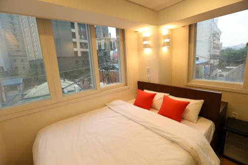 1 dormitorio con 1 cama con 2 almohadas rojas en Philstay Dongdaemun Economic, en Seúl