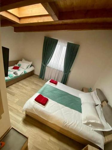 a bedroom with two beds and a large window at Pensiunea CUZA in Borşa