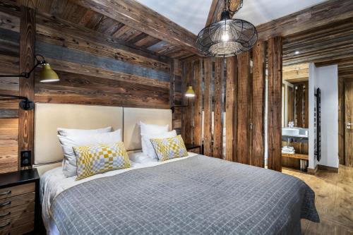 a bedroom with a bed and a wooden wall at Résidence Oursnoir - Chalets pour 10 Personnes 224 in Val-d'Isère