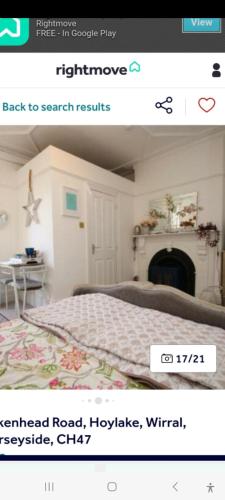 página de un dormitorio con cama y chimenea en Beautiful self-contained annex/Cottage, en Hoylake