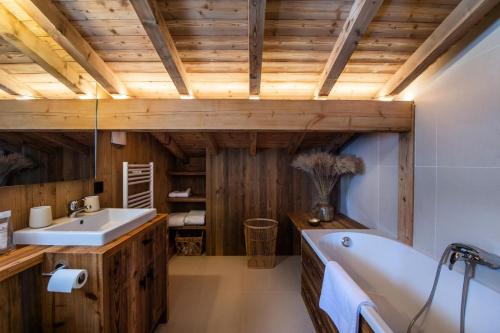 a bathroom with a tub and a sink at Résidence Fanny A La Montagne - Chalets pour 11 Personnes 254 in Megève