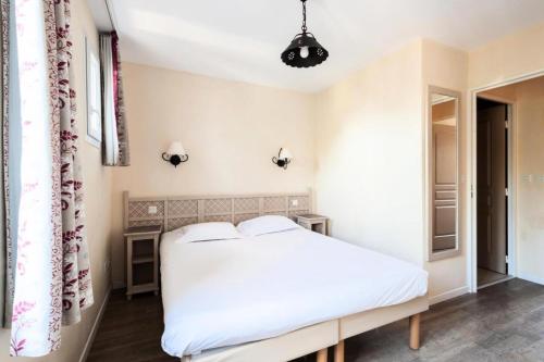 - une chambre avec un lit blanc et une fenêtre dans l'établissement Les Coteaux de Pont Royal en Provence - maeva Home - Appartement 3 pièces 6 214, à Mallemort