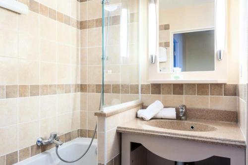 La salle de bains est pourvue d'un lavabo et d'une douche. dans l'établissement Les Coteaux de Pont Royal en Provence - maeva Home - Appartement 3 pièces 6 214, à Mallemort