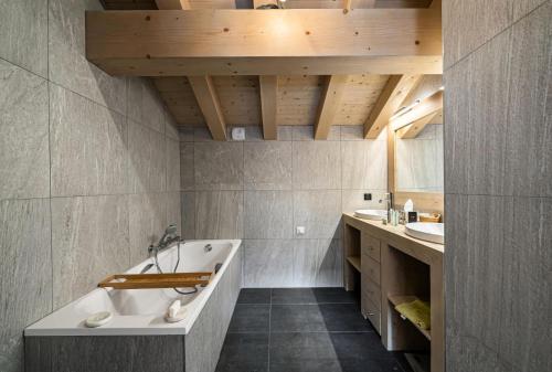 a bathroom with a large tub and two sinks at Résidence Saint Joseph - Chalets pour 11 Personnes 294 in Val-d'Isère