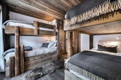 Ce lit se trouve dans un dortoir doté de 2 lits superposés et de murs en bois. dans l'établissement Residence La Canadienne - Pièces 524, à Val dʼIsère