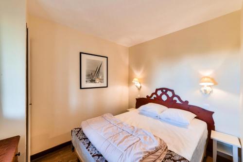 - une chambre avec un lit doté de draps blancs et d'oreillers bleus dans l'établissement La Résidence du Golf - maeva Home - Appartement 2 pièces 4 personnes - Sélection MAE-8034, à Deauville