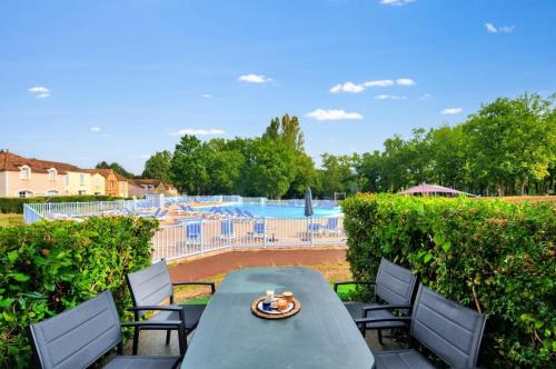 - une table et des chaises sur une terrasse avec piscine dans l'établissement La résidence du Lac - maeva Home - Maison 3 pièces 6 personnes - Prestige MAE-8044, à Monflanquin