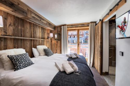 two beds in a room with wooden walls at Résidence Grizzly - 4 Pièces pour 8 Personnes 634 in Val-d'Isère