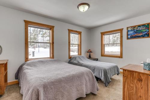 two beds in a room with two windows at Montello Cabin on Buffalo Lake with Dock and Fire Pit! in Montello