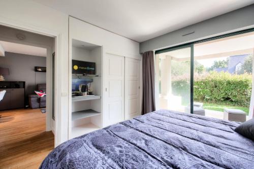 um quarto com uma cama e uma grande janela em Résidence Le Saint Denac - maeva Home - Appartement 2 pièces 4 personnes - 234 em Saint-André-des-Eaux