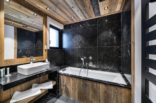 baño con bañera grande y lavamanos en Résidence La Tapia - Chalets pour 14 Personnes 364 en Val dʼIsère
