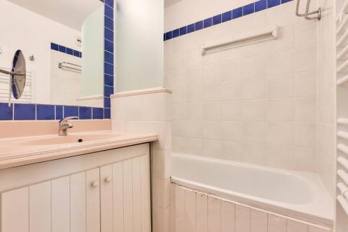 une salle de bain avec un lavabo et une baignoire dans l'établissement Résidence Bleu Marine - maeva Home - Appartement 3 pièces 6 personnes - Prestige MAE-5244, à Lacanau