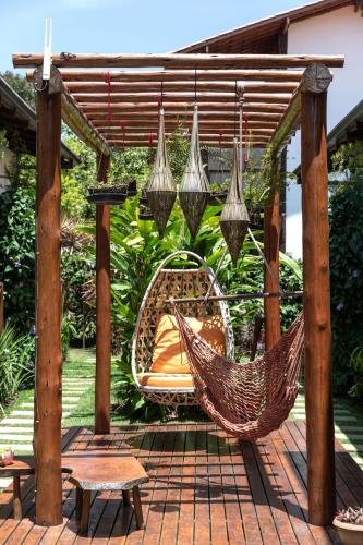 a hammock on a patio under a pergola at Vila Lua de Taipu - Taipu de Fora in Barra Grande