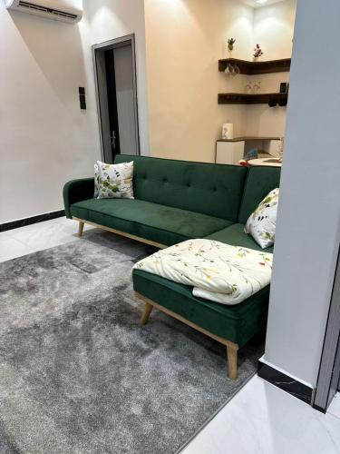 a green couch sitting in a living room at Studio meublé calme et cosy in Dakar
