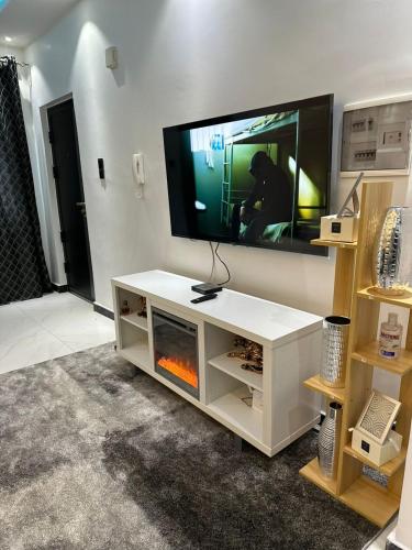 ein weißes Entertainment-Center mit einem TV und einem Kamin in der Unterkunft Studio meublé calme et cosy in Dakar