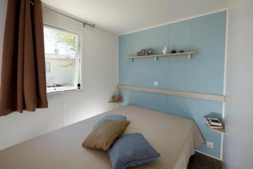 a small bedroom with a bed with a window at Mobilhome 4 étoiles - Piscine - eecb00 in Aubigny