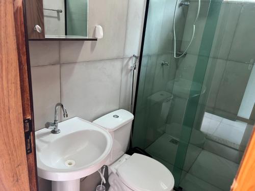 La salle de bains est pourvue de toilettes, d'un lavabo et d'une douche. dans l'établissement Pousada Encanto dos Mognos, à Ibicoara