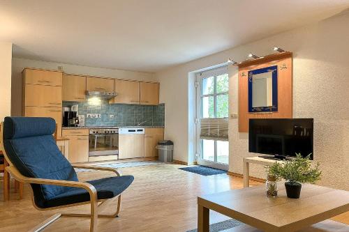 a living room with a chair and a tv and a table at Villa Triton Souterrain Wohnung 07 in Boltenhagen