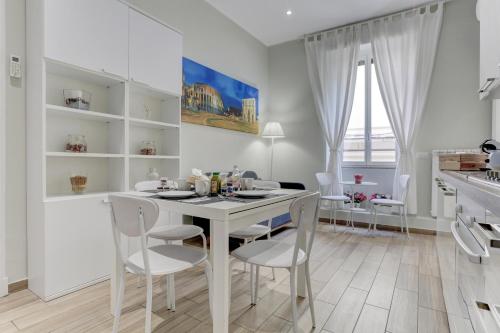 a kitchen and dining room with a white table and chairs at Appartamento Santi Quattro - Colosseo in Rome