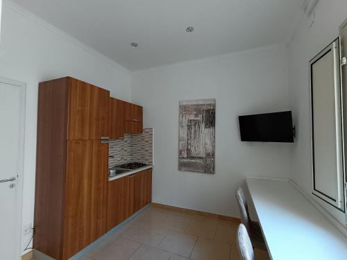Habitación con mesa y TV en la pared. en OtrantoCasa en Otranto
