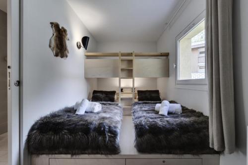um quarto com 2 camas e uma cama alta em Résidence RÉsidence Les Oreades - 3 Pièces pour 4 Personnes 924 em Val dʼIsère