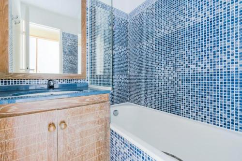 une salle de bain avec une baignoire et un lavabo et une baignoire dans l'établissement Résidence le Hameau de Cap Esterel - maeva Home - Appartement 2 pièces 5 personnes - Budget MAE-5324, à Saint-Raphaël