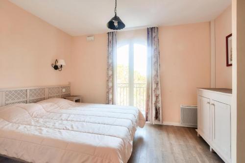une chambre avec un grand lit et une fenêtre dans l'établissement Les Coteaux de Pont Royal en Provence - maeva Home - Maison climatisée 3 pièces 6 personnes - Sélection MAE-5714, à Mallemort