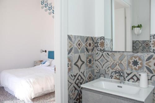 een badkamer met een bed, een wastafel en een spiegel bij Buen Aire in Cagliari