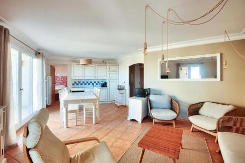 un salon avec une table et des chaises et une cuisine dans l'établissement Village Pont Royal en Provence - maeva Home - Appartement climatisé 4 pièces 6 personnes - Prestige MAE-3234, à Mallemort