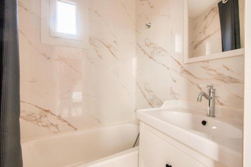 une salle de bain blanche avec un lavabo et une baignoire dans l'établissement Village Pont Royal en Provence - maeva Home - Appartement climatisé 3 pièces 4 personnes avec terrasse aménagée - Prestige - super Home MAE-3084, à Mallemort