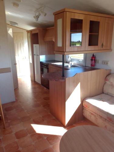 a kitchen with wooden cabinets and a counter top at Drottning Ödas Boende in Degerhamn
