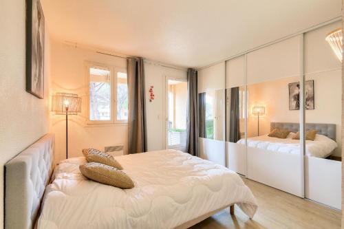 ein Schlafzimmer mit zwei Betten und einem großen Spiegel in der Unterkunft Résidence Saint-Raphaël Valescure - maeva Home - Appartement avec vue sur le golf 2 pièces 4 personnes - Prestige - super Home MAE-6264 in Valescure