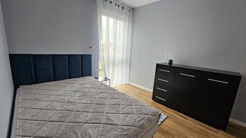 um quarto com uma cama, uma cómoda e uma janela em Domek Żerniczanka em Żerniki Wroctawskie