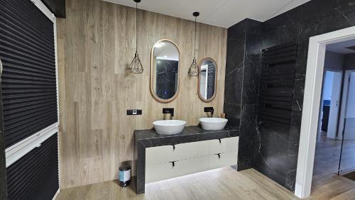 a bathroom with two sinks and two mirrors at Domek Żerniczanka in Żerniki Wroctawskie