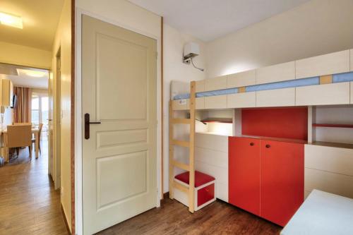 Cette petite chambre comprend des lits superposés et une porte. dans l'établissement Résidence le Village de Cap Esterel - maeva Home - Studio vue mer 4 personnes - Confort MAE-2514, à Saint-Raphaël