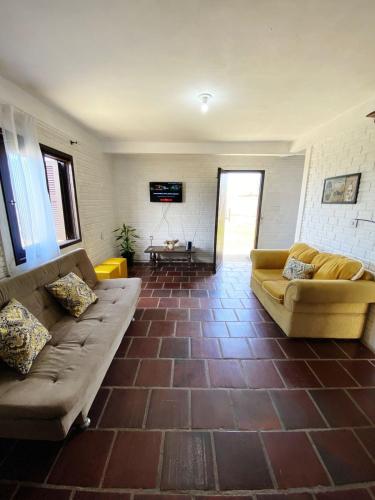 a living room with a couch and a tv at Casa Dunas in Passo de Torres