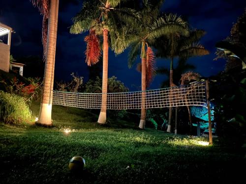 a volleyball net in front of palm trees at night at Palmeras del Mirador - Hotel Boutique Campestre en La Vega a 1h de Bogotá in La Vega