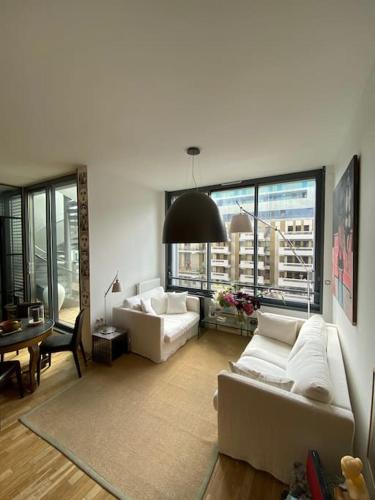 - un salon avec deux canapés blancs et une table dans l'établissement Penthouse Luxueux avec Terrasse Panoramique, à Boulogne-Billancourt