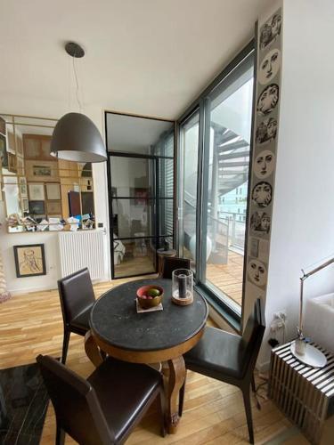 - une salle à manger avec une table et des chaises dans l'établissement Penthouse Luxueux avec Terrasse Panoramique, à Boulogne-Billancourt