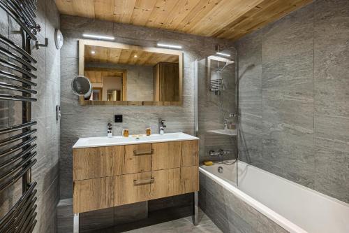 a bathroom with a sink and a bath tub at Résidence Chantemerle - 5 Pièces pour 8 Personnes 344 in Courchevel