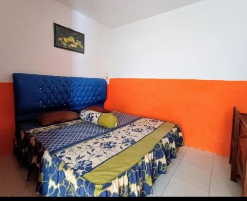 a bed with a blue headboard in a room at Orion Jaya Kost in Ketapang