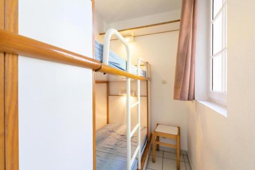 Cette petite chambre comprend des lits superposés et une chaise. dans l'établissement Résidence le Hameau de Cap Esterel - maeva Home - Studio 5 personnes - Sélection MAE-3561, à Saint-Raphaël