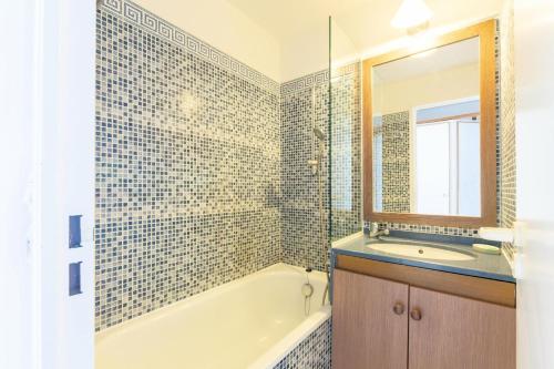 une salle de bain avec une baignoire, un lavabo et un miroir dans l'établissement Résidence le Hameau de Cap Esterel - maeva Home - Studio 5 personnes - Sélection MAE-3561, à Saint-Raphaël