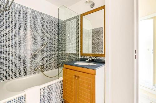 une salle de bain avec un lavabo, une baignoire et un miroir dans l'établissement Résidence le Hameau de Cap Esterel - maeva Home - Studio 5 personnes - Confort MAE-5081, à Saint-Raphaël