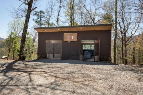 a building with a basketball hoop in the woods at Mountain Yurt - Hot Showers in Bryson City